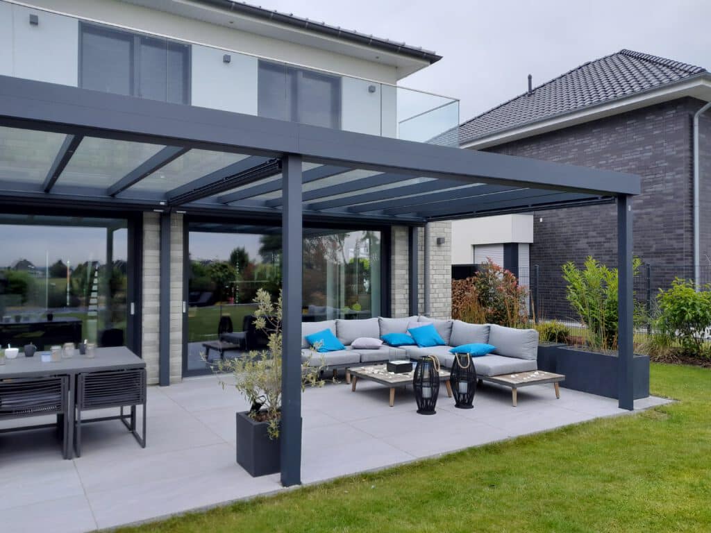 Eine Terrassenüberdachung aus Metall in Dortmund vor einem haus mit roten Backsteinen