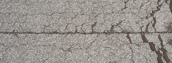 Die alte und spröde Abdichtung eines Flachdaches ist durch einen großen Riss beschädigt